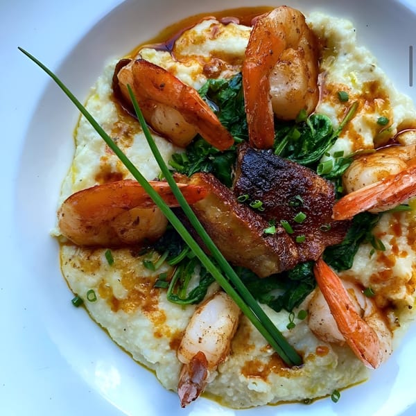 Shrimp and grits with seared pork belly, spinach, and chives, a New American dish from The Manor.